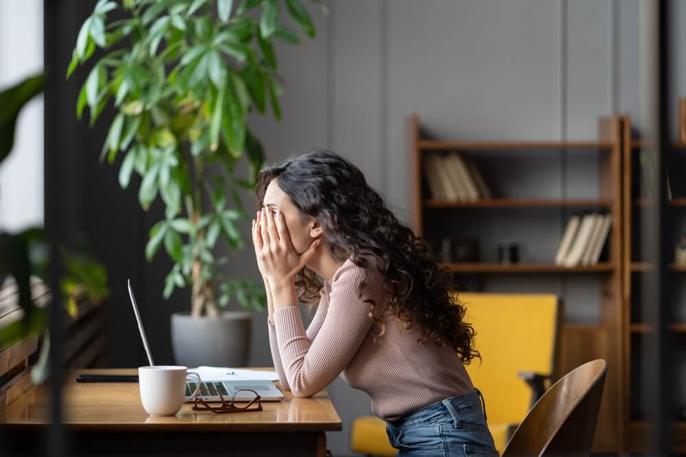 stressed woman with her head in her hands