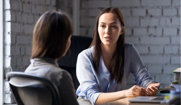 Women colleagues having a serious discussion in an office.