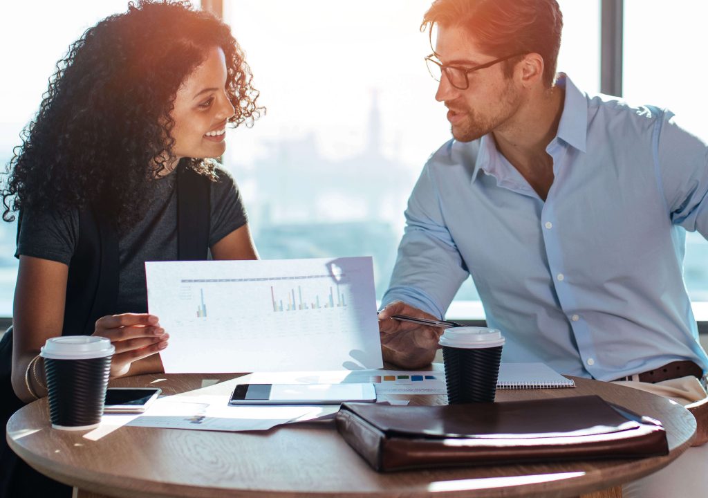 man and woman in office looking at paperwork