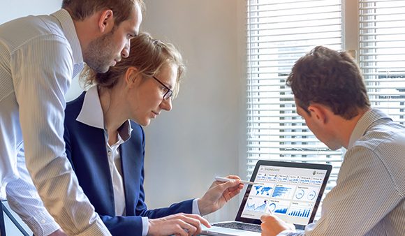 employees looking at stats on laptop