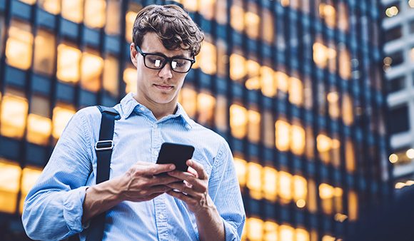 man looking at phone in city centre