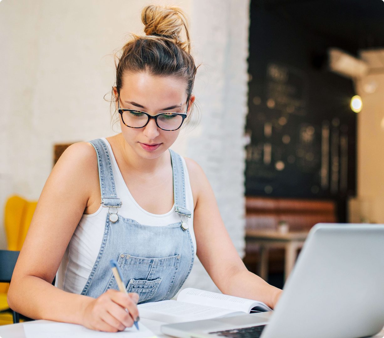 woman taking notes with open book