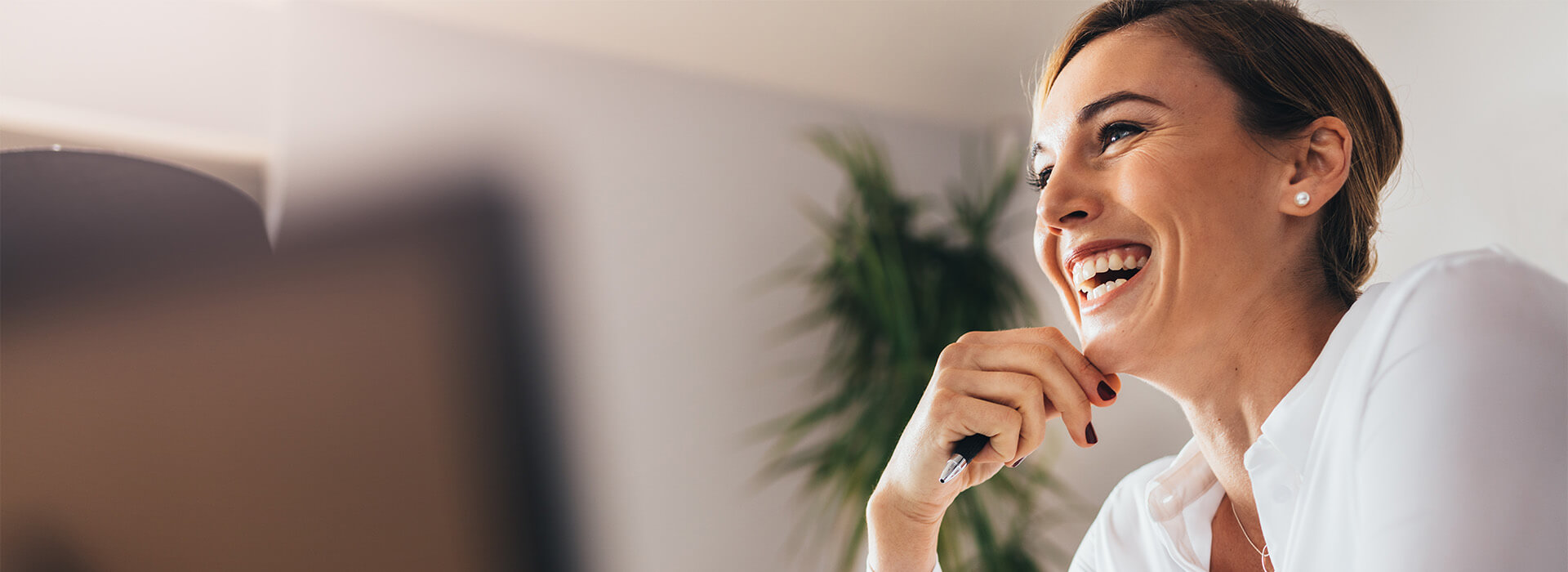 woman laughing and holding a pen