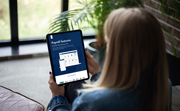 Woman reading Next Generation payroll & HR software brochure