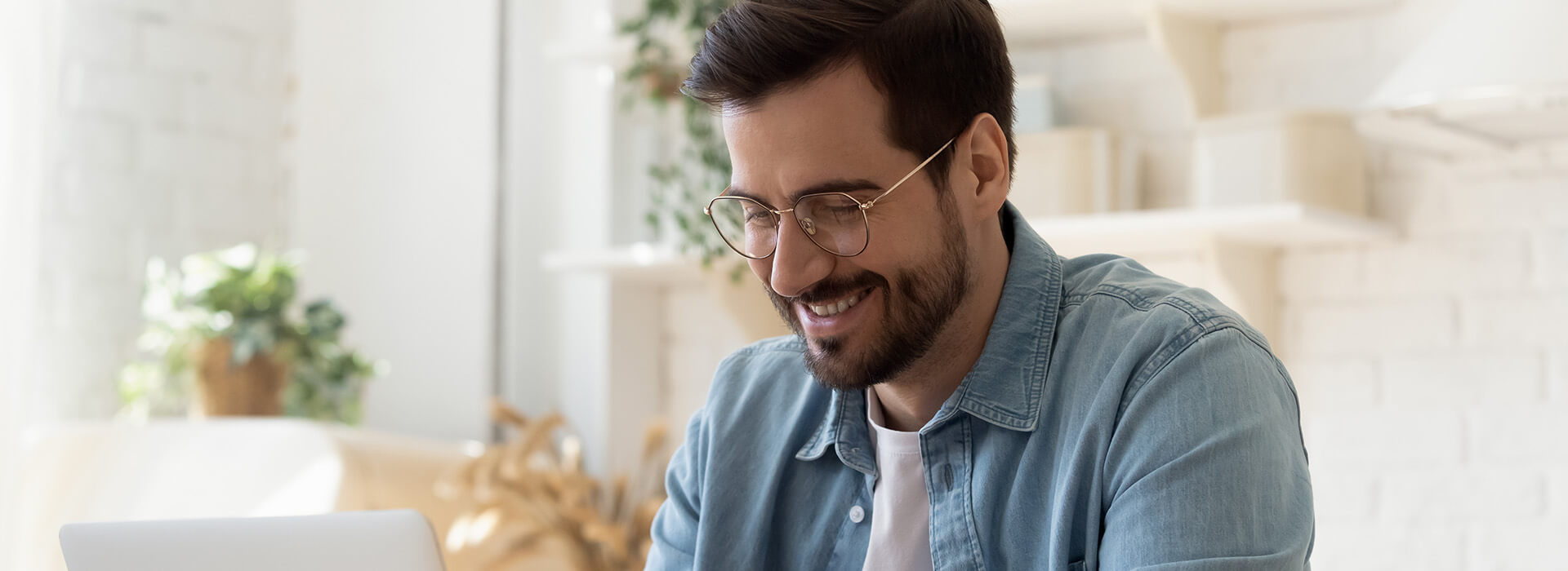 man smiling at his laptop