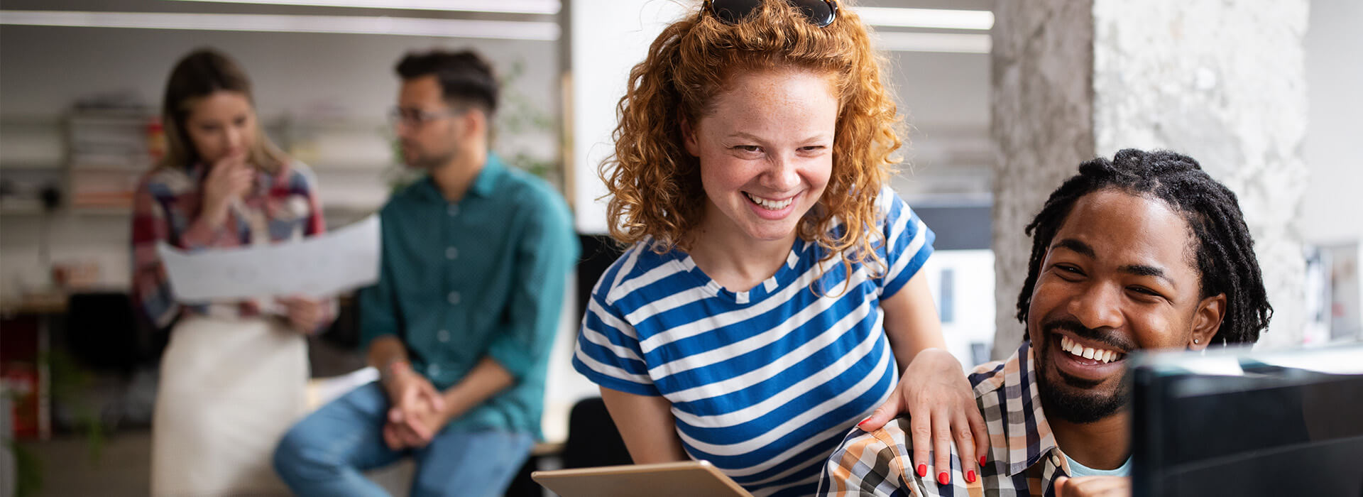 two people laughing at something on a PC