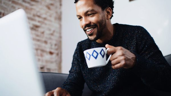 man drinking coffee at laptop