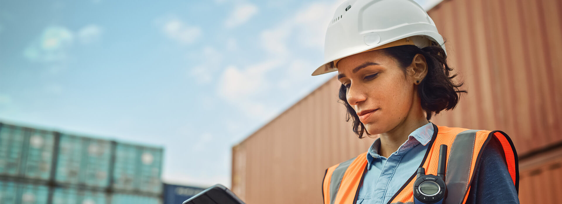 woman in safety gear looking at a laptop