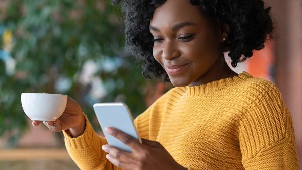 woman smiling at phone in cafe