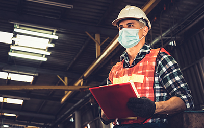 man wearing hard had with clipboard