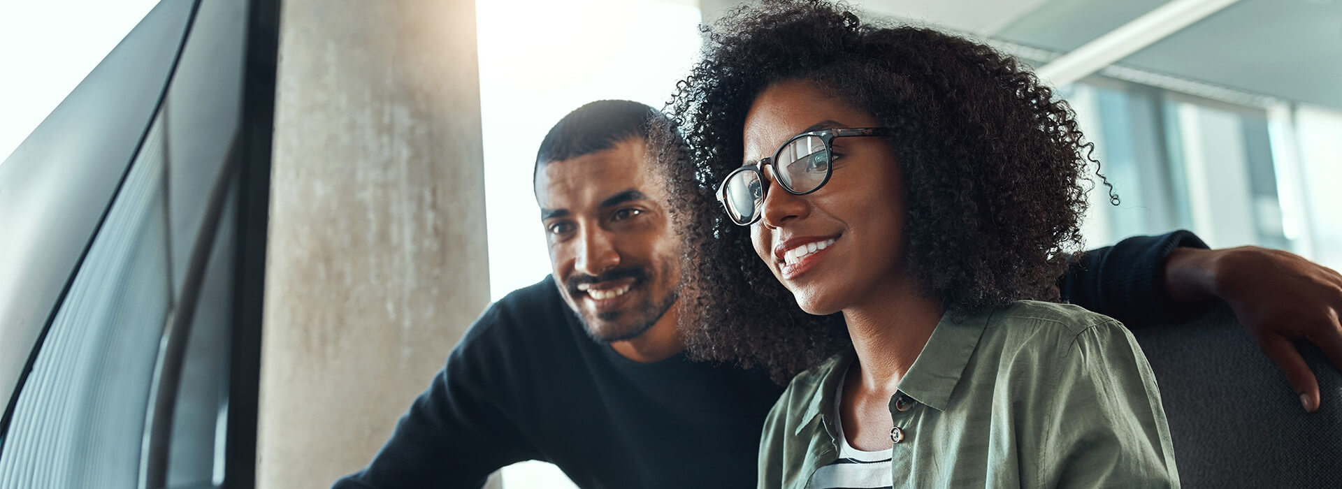 man and woman smiling at computer