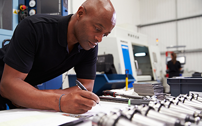 man writing in workbook