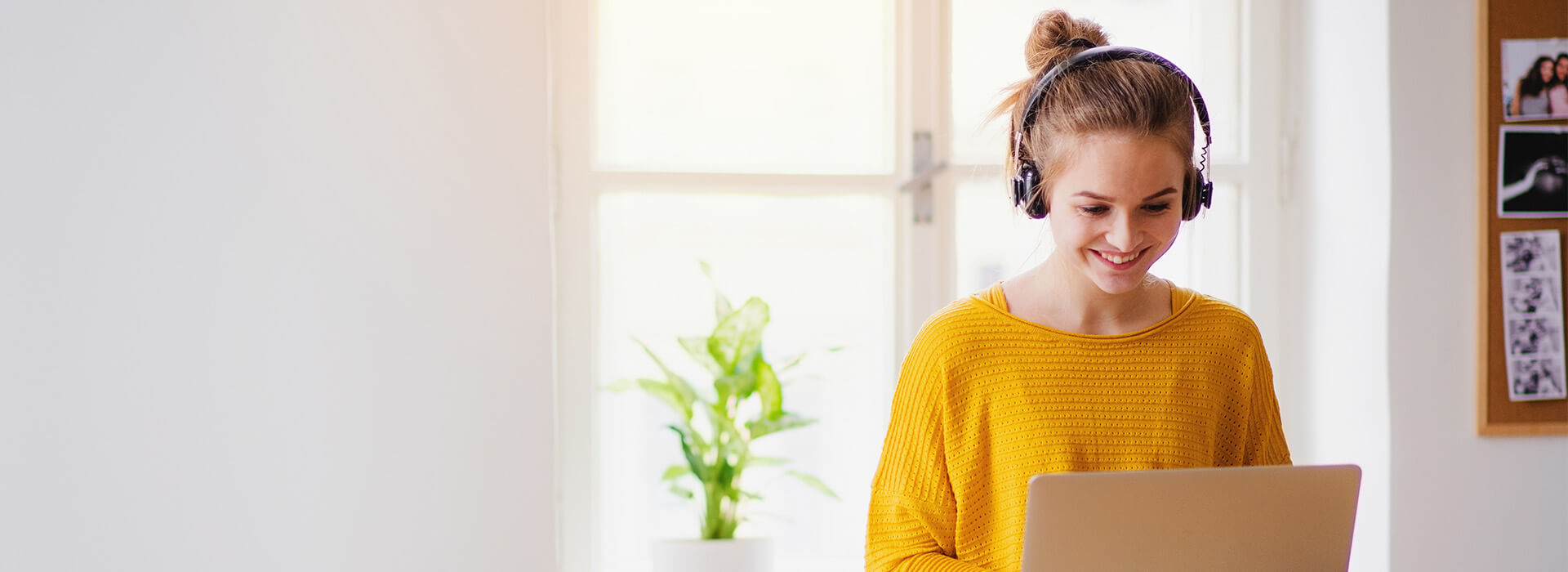 woman with headphones on smiling at laptop