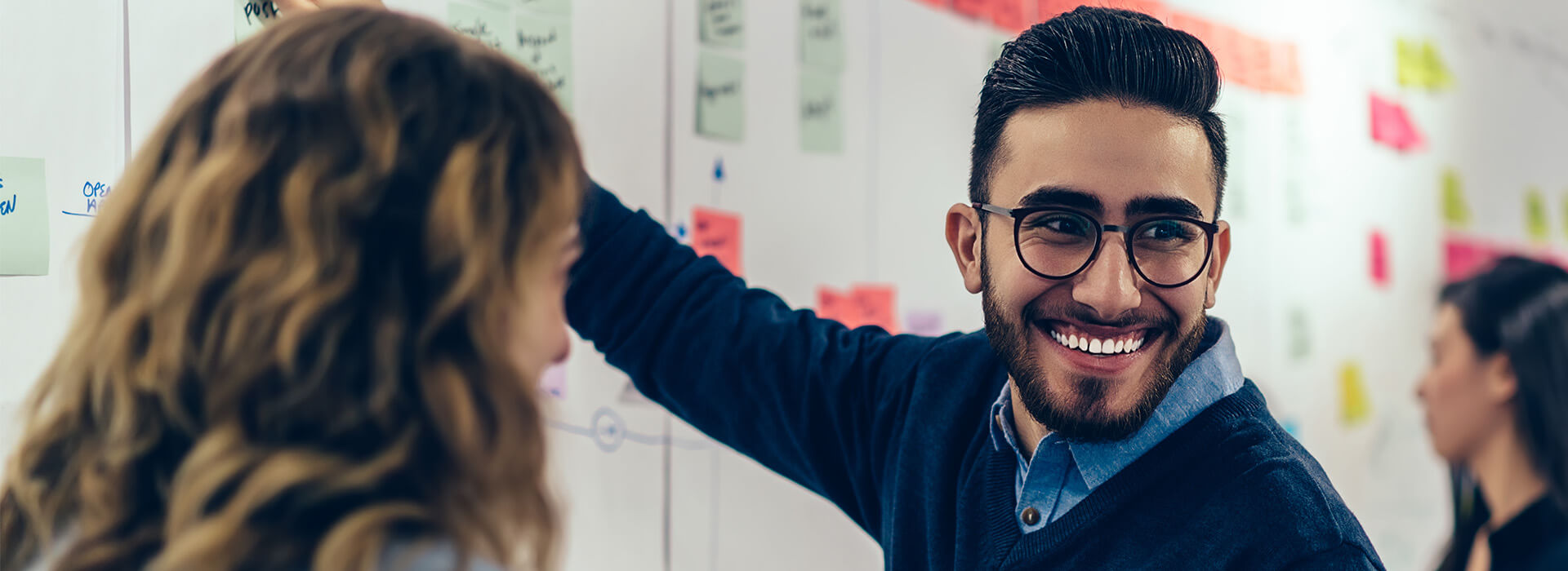 man smiling while using whiteboard