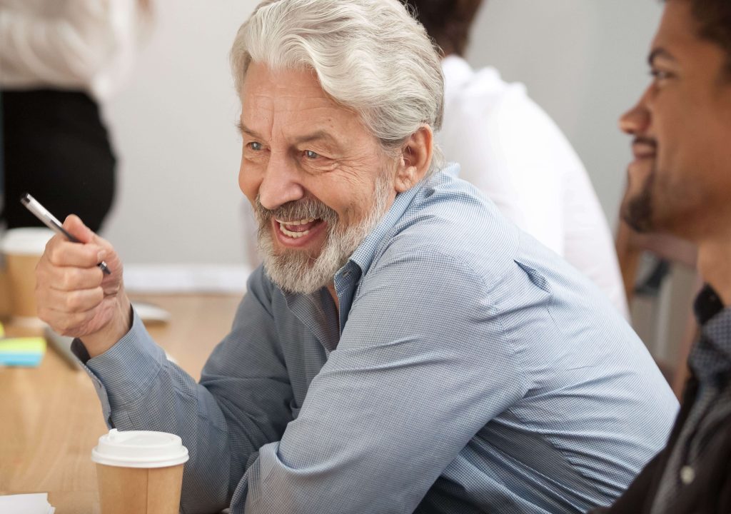 man holding pen laughing