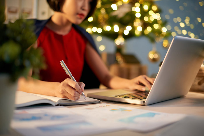 woman on laptop with christmas tree