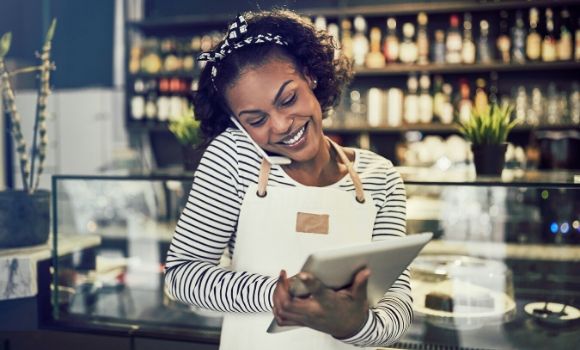 woman on the phone smiling while on ipad