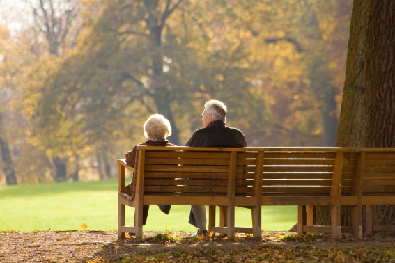 old couple sitting on a park bench