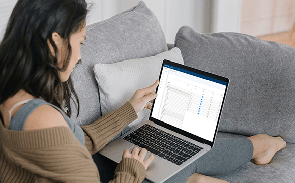 woman sat on sofa working on laptop