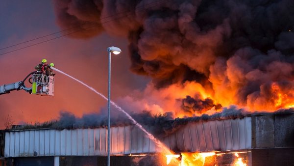 Fire brigade putting out large fire in building.