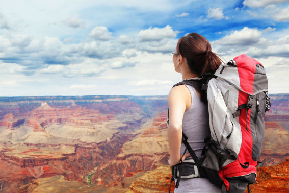 hiker stood on edge of the grand canyon