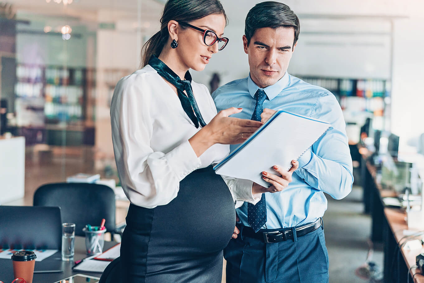 pregnant woman and man looking at papers