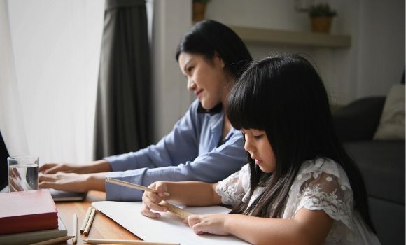 mother and daughter working together at table