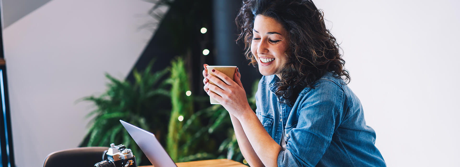 woman smiling at laptop with coffee