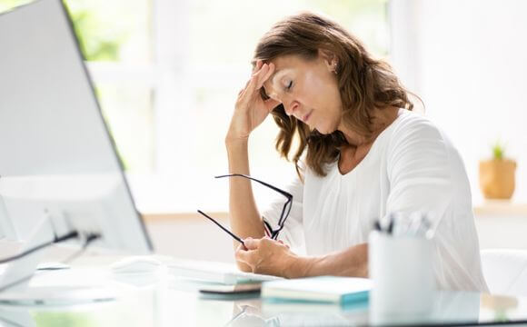 stressed woman holding glasses