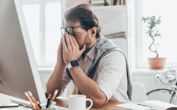 distressed man sat at laptop