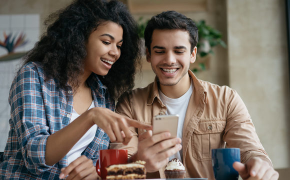 two people laughing at a phone