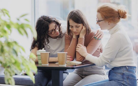 woman being comforted by her friends