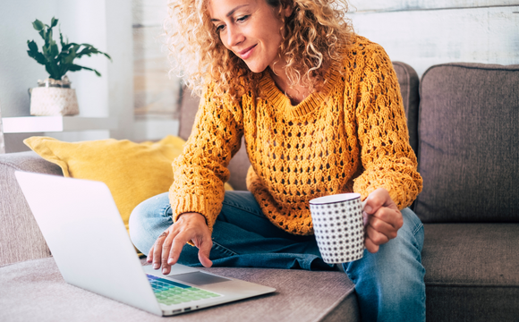 woman working at laptop with a coffee