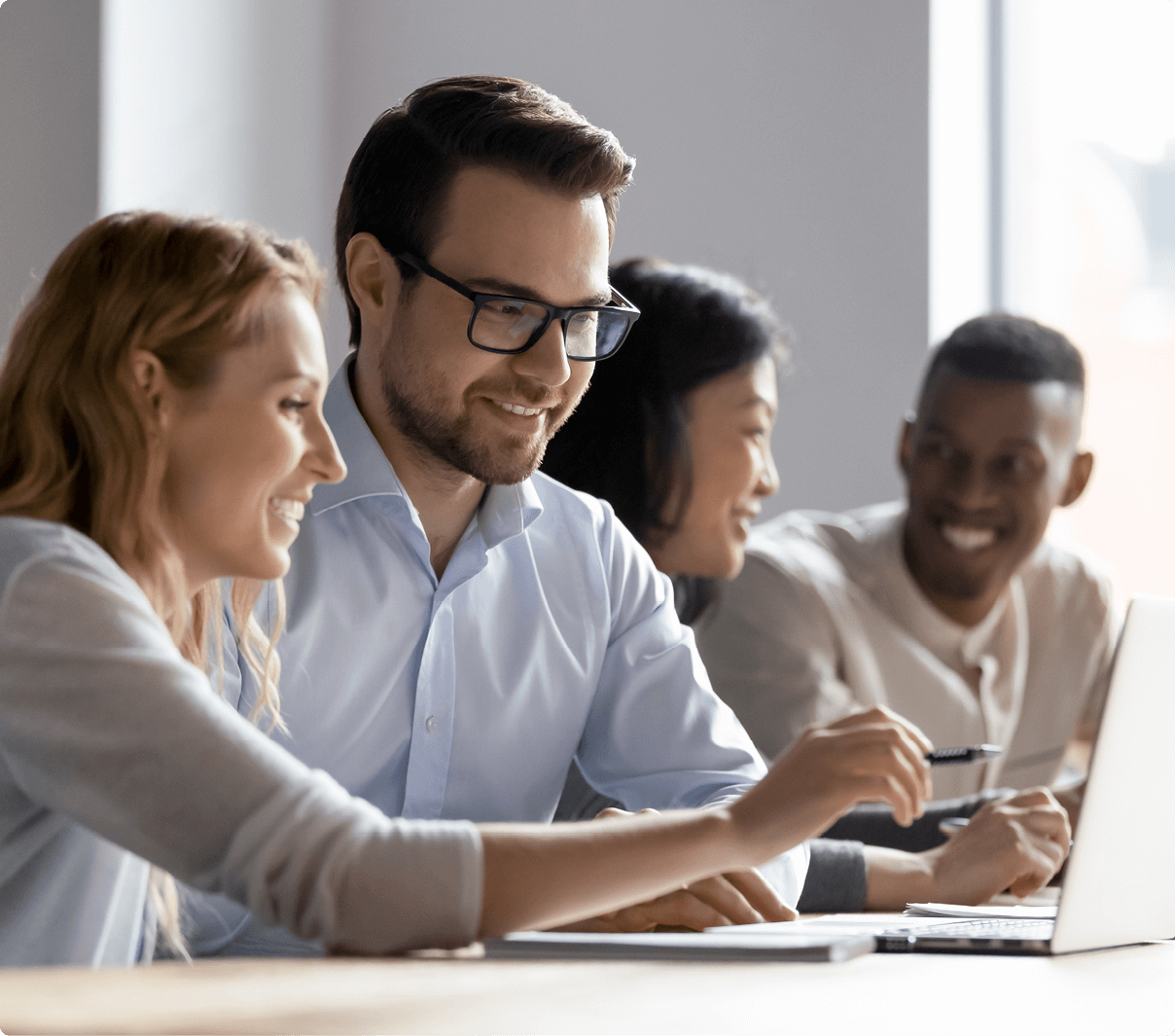 people smiling at laptops and discussing