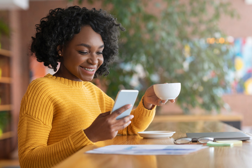 woman smiling at phone in cafe