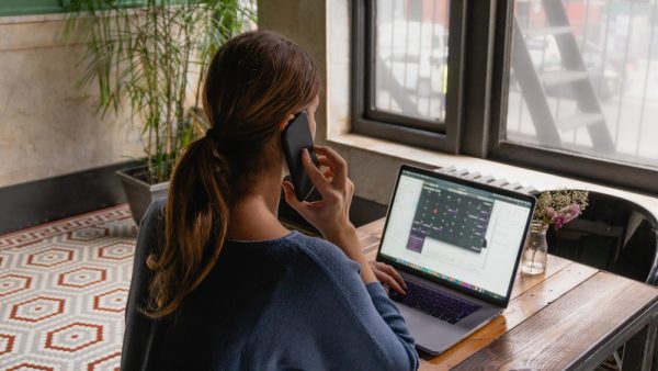 woman on the phone typing on laptop