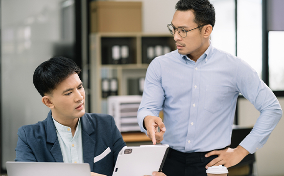 concerned employer pointing at papers employee is holding