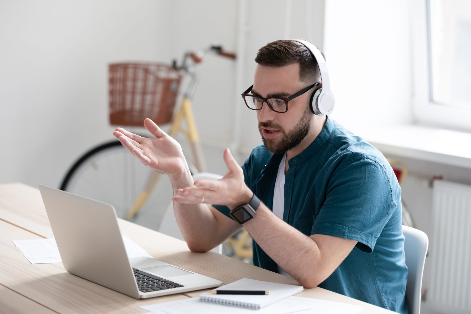 man with headphones on talking to laptop