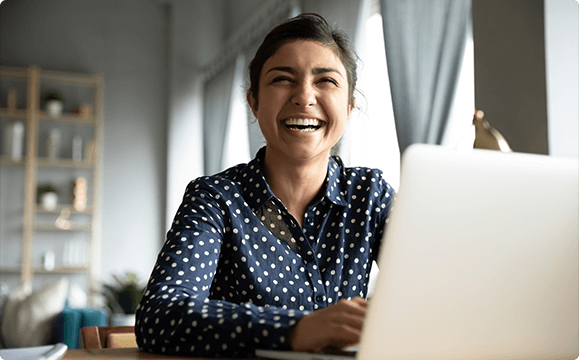 woman sat at laptop laughing