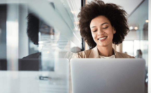 woman sat at laptop smiling