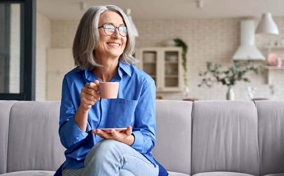 elderly woman holding tea cup smiling