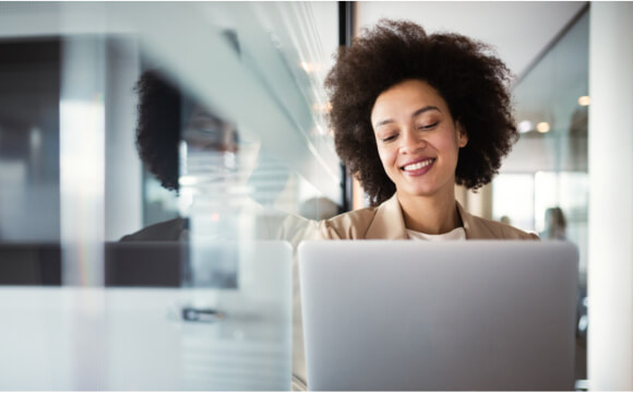woman smiling down at laptop