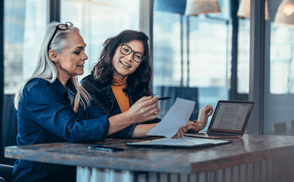 two women sat discussing paperwork