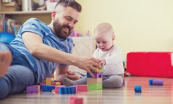 Dad with baby enjoying paternity benefits pay
